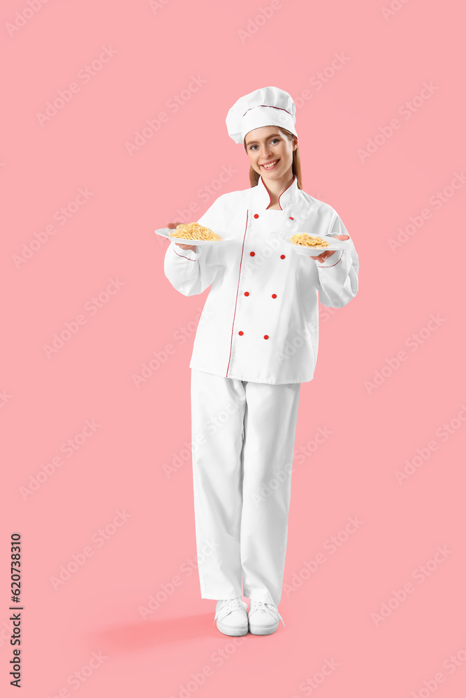 Female chef with plates of tasty pasta on pink background