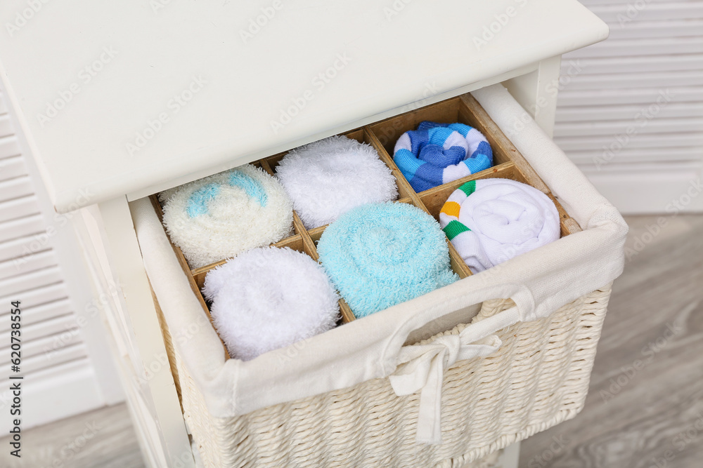 Drawer with basket of different socks in room, closeup