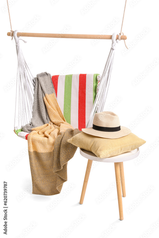 Cozy striped hammock and cushion with hat on stool against white background