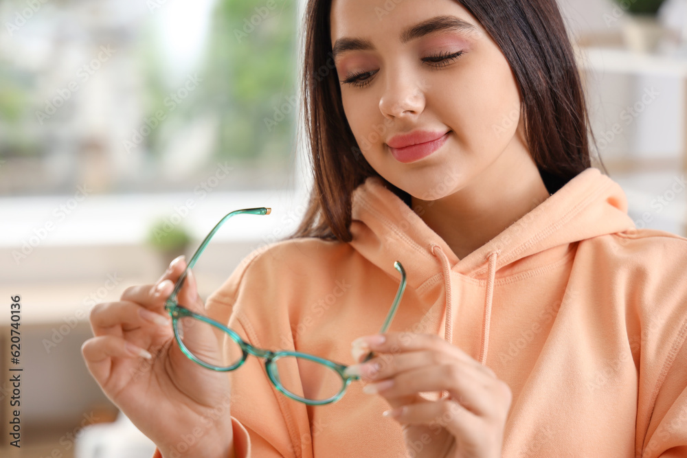 Beautiful young woman with glasses at home