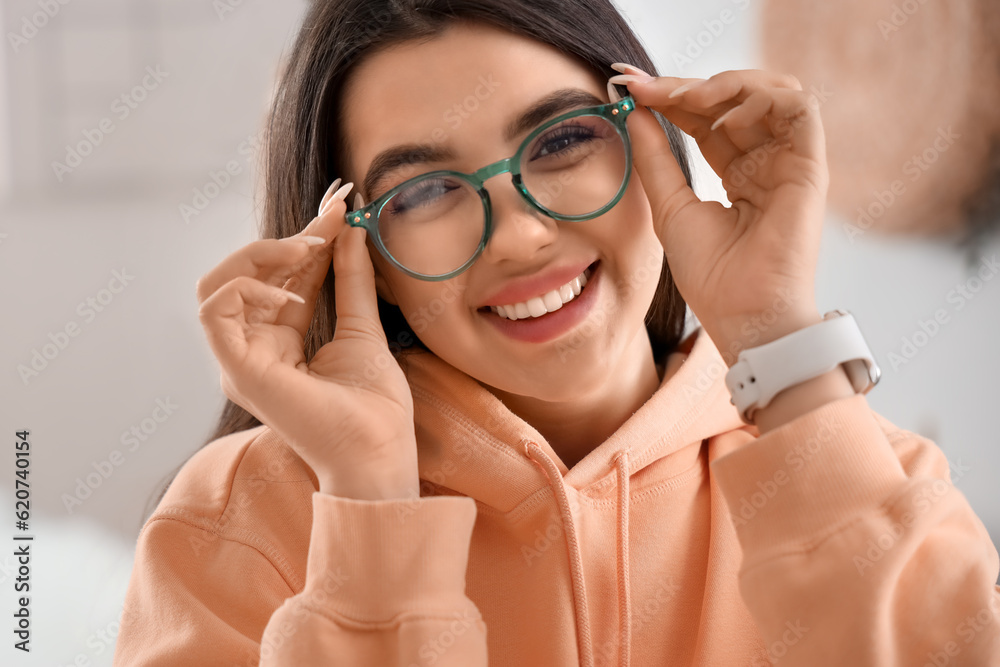 Beautiful happy young woman wearing glasses at home