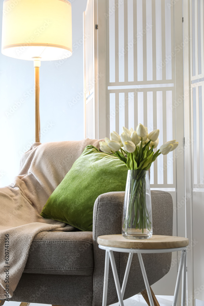 Vase with tulips on table in living room