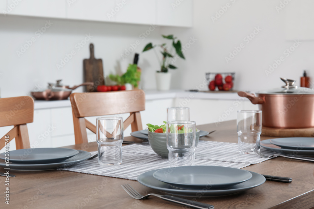 Wooden island tabled served for dinner in modern kitchen