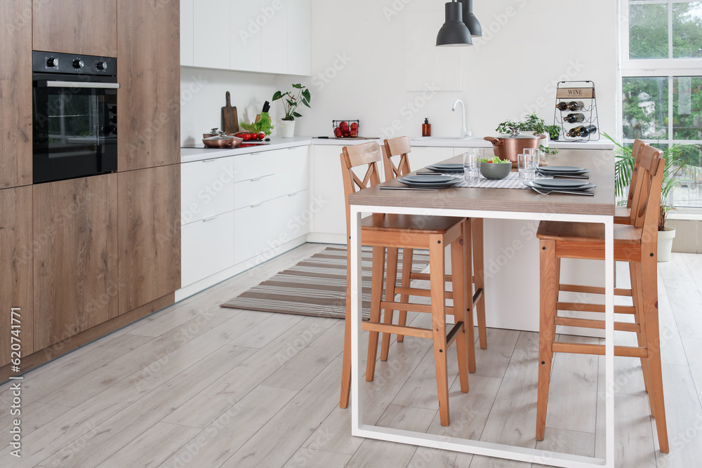 Interior of modern kitchen with served island table