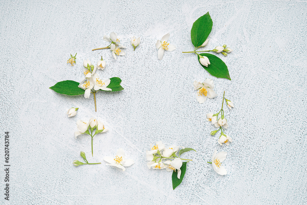 Frame made of beautiful jasmine flowers on light background