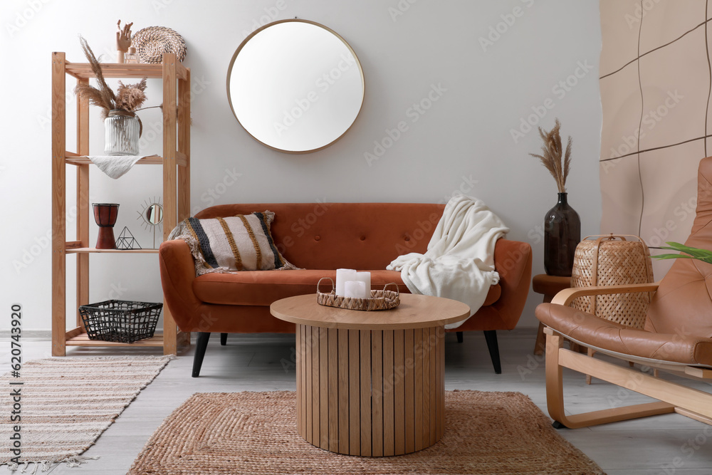 Interior of living room with brown sofa, armchair, coffee table and mirror