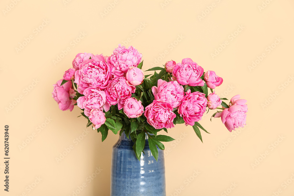 Vase of pink peonies on beige background