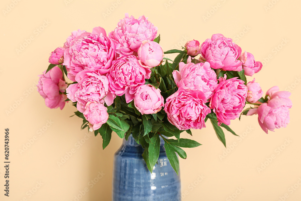 Vase of pink peonies on beige background