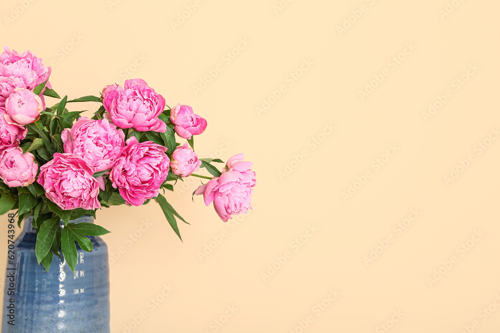 Vase of pink peonies on beige background