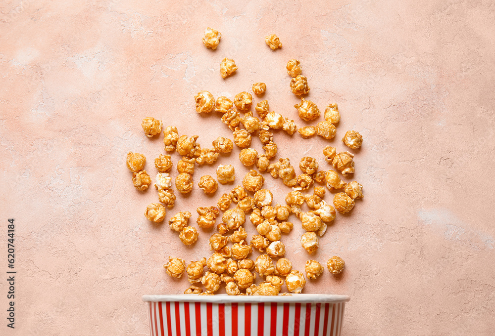 Bucket with tasty popcorn on pink background