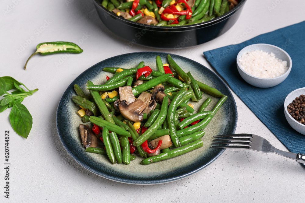 Plate with different vegetables on light background