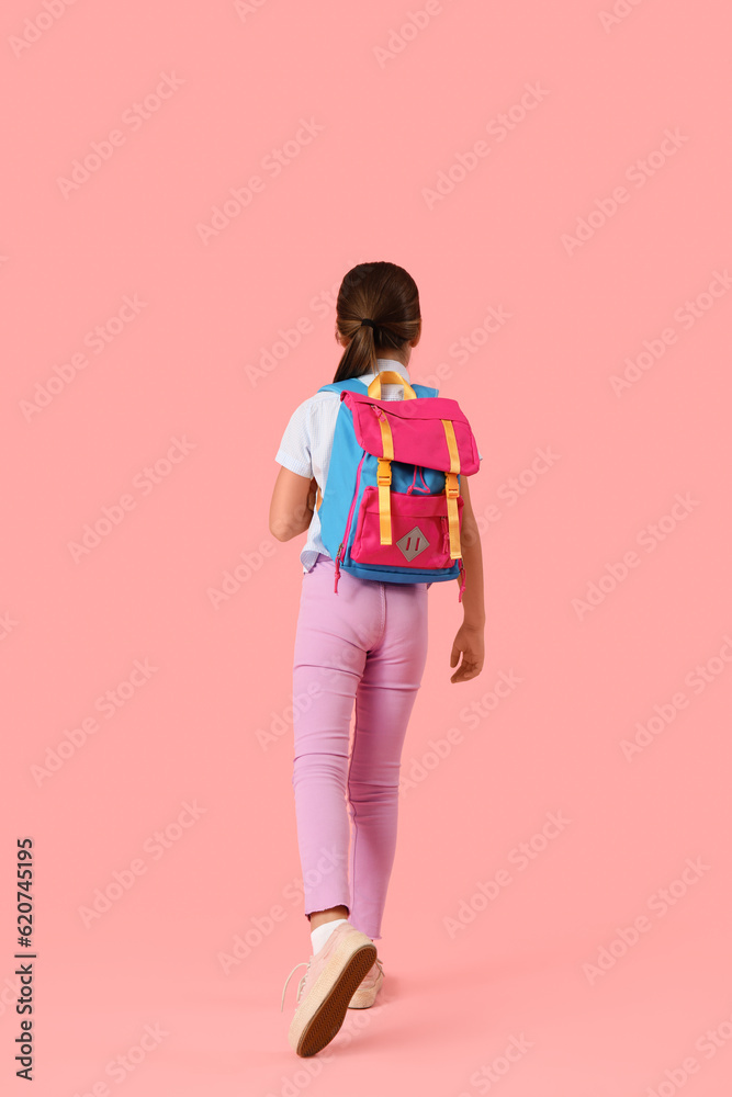 Little girl with backpack on pink background, back view