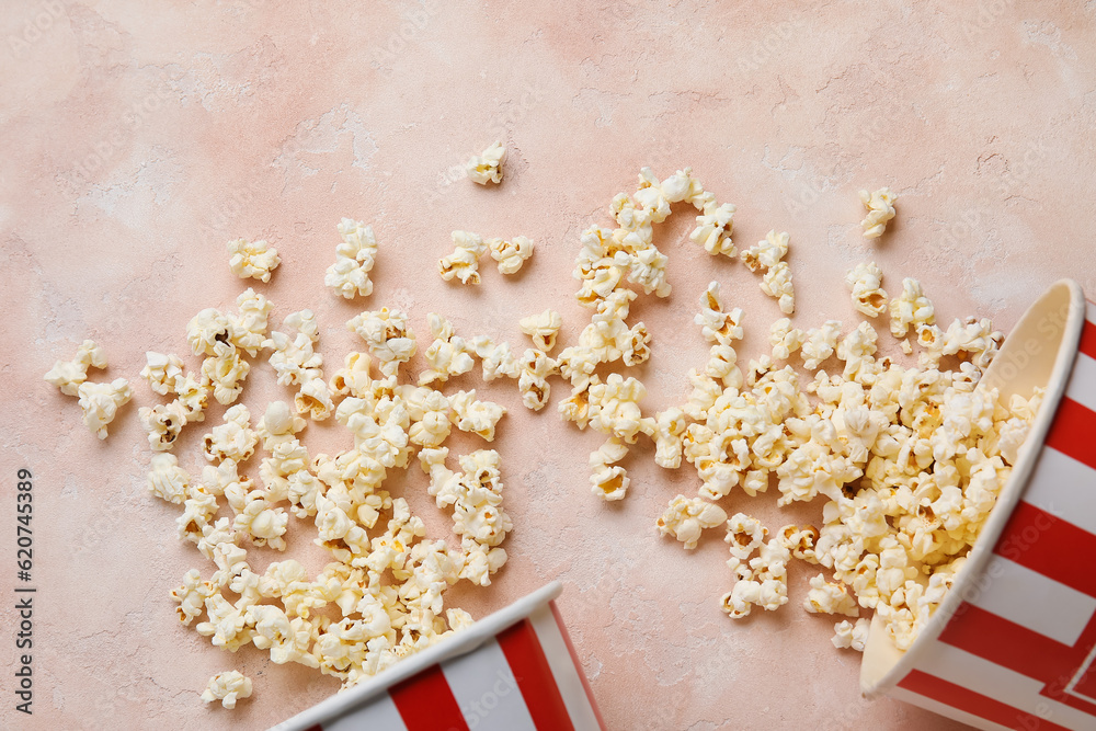 Buckets with tasty popcorn on pink background