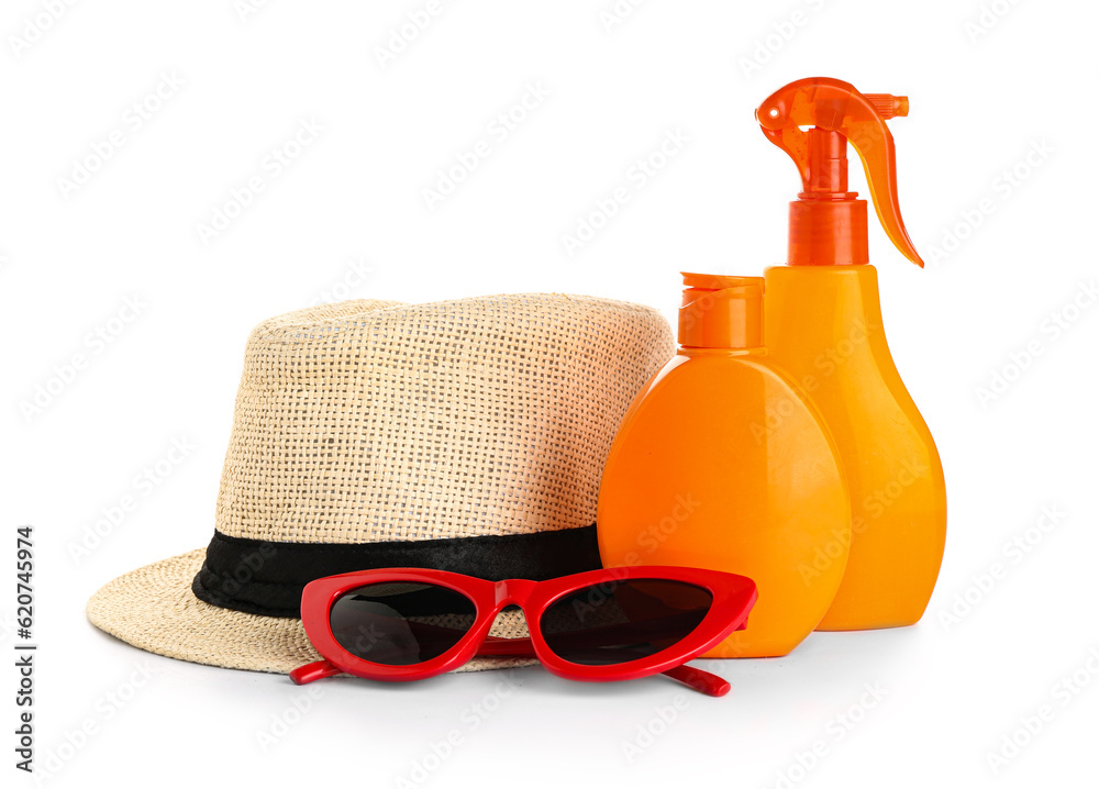 Wicker summer hat with sunglasses and bottles of sunscreen cream isolated on white background