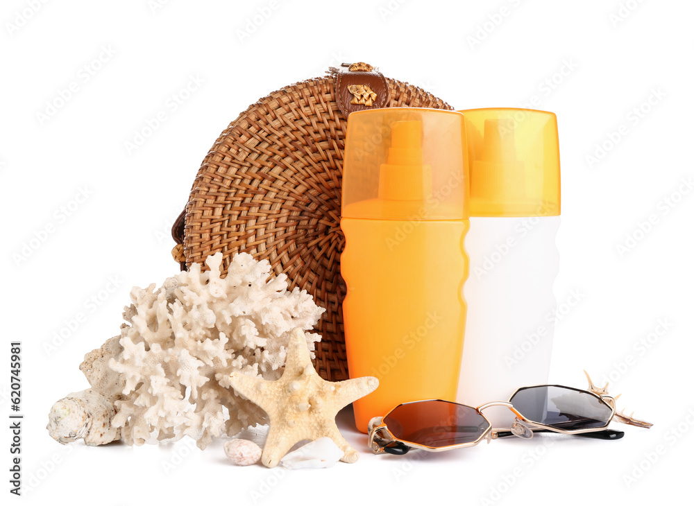 Wicker bag with sunglasses, bottles of sunscreen cream and coral isolated on white background