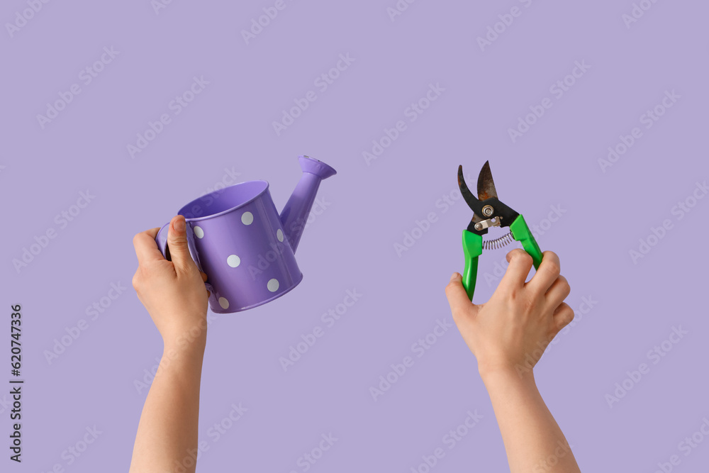 Gardener with watering can and secateurs on lilac background