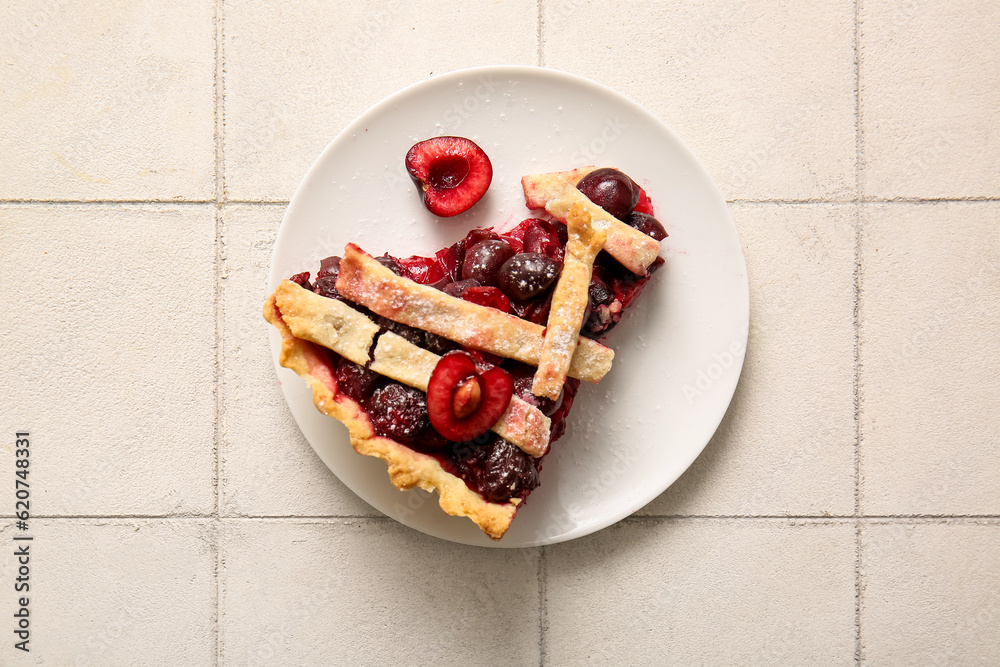 Plate with piece of tasty cherry pie on white tile background