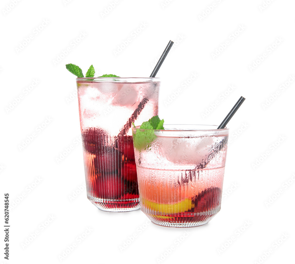 Glasses of tasty cherry lemonade with lime and mint on white background