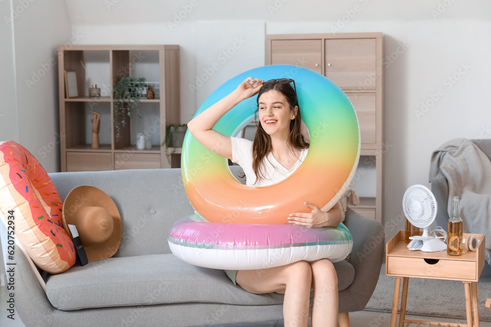 Young woman with swim rings ready for summer vacation at home