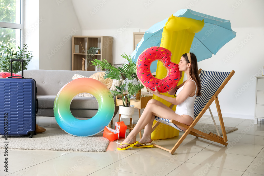 Young woman with swim ring ready for summer vacation at home