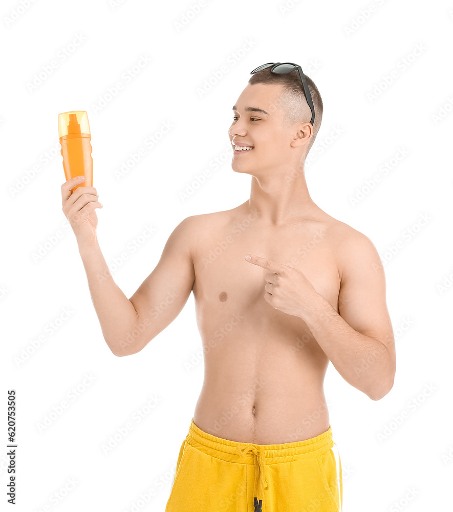 Happy young man in sunglasses pointing at bottle of sunscreen cream isolated on white background