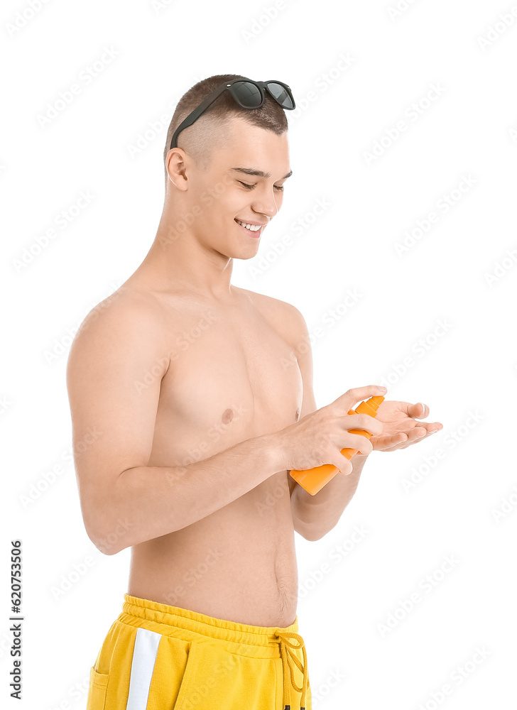 Happy young man in sunglasses applying sunscreen cream isolated on white background