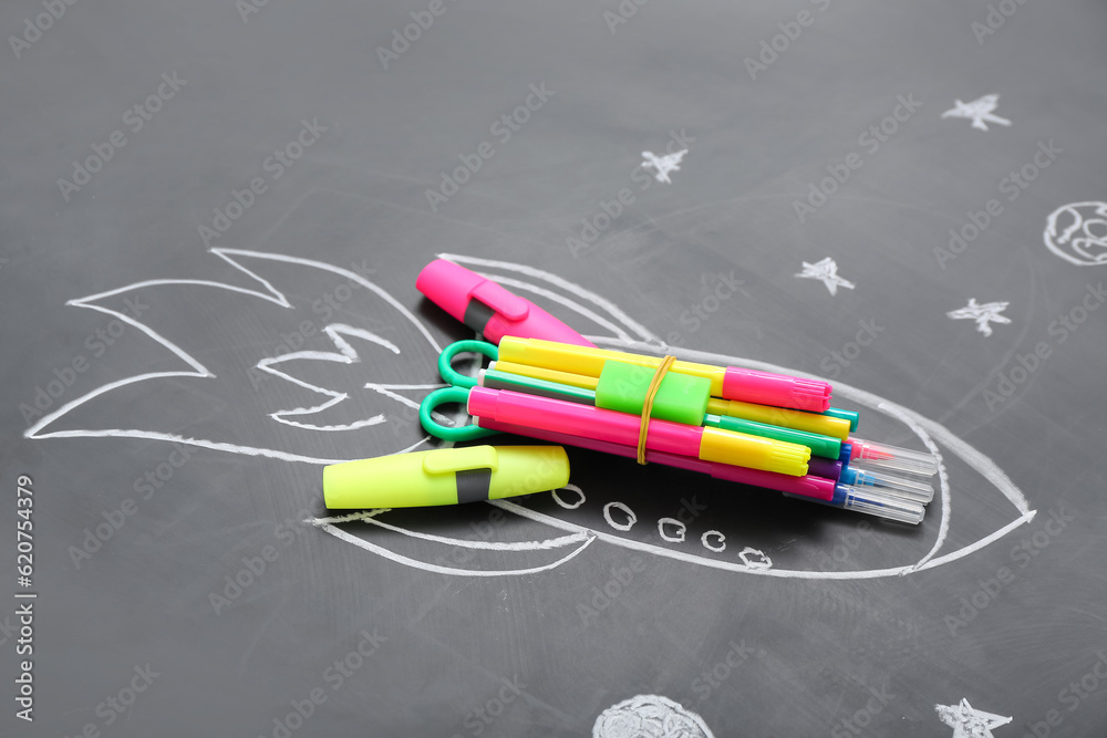 Drawn rocket with stationery on black background