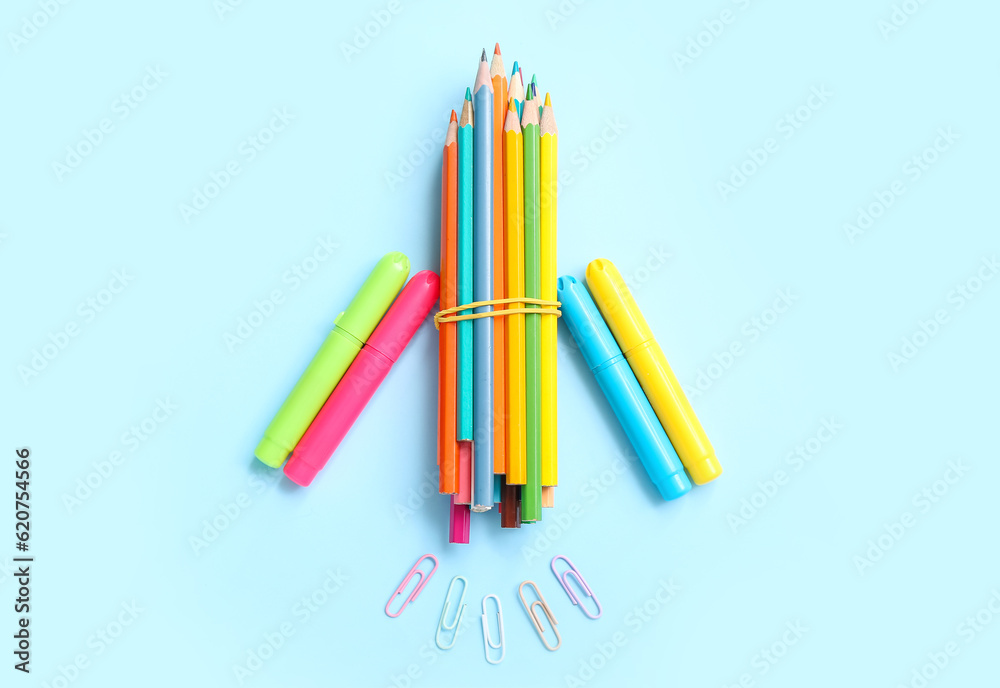 Rocket made of stationery on light blue background