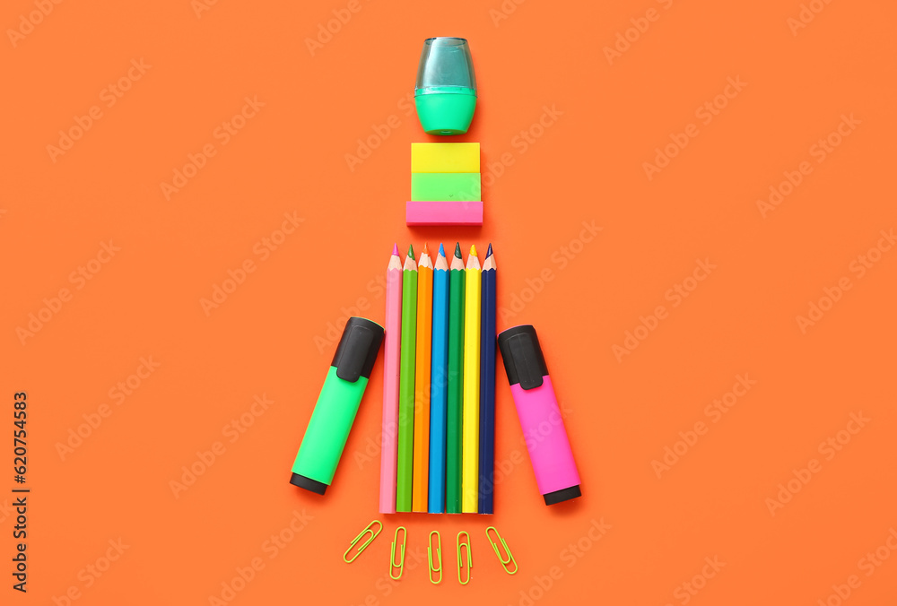 Rocket made of stationery on red background