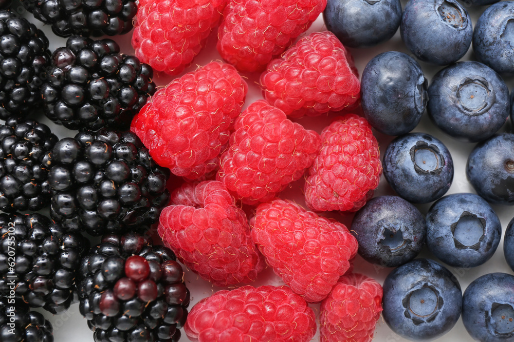 Fresh raspberry, blackberry and blueberry on light background, closeup