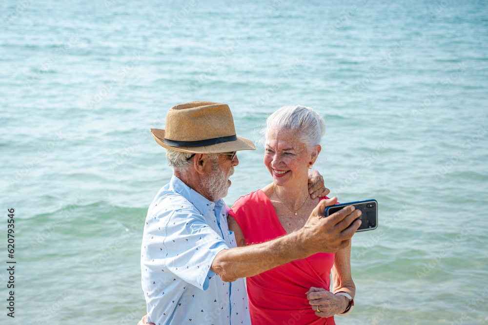 Mature couple taking pictures together by the sea during summer seaside trip,Happy retirement,Ocean 