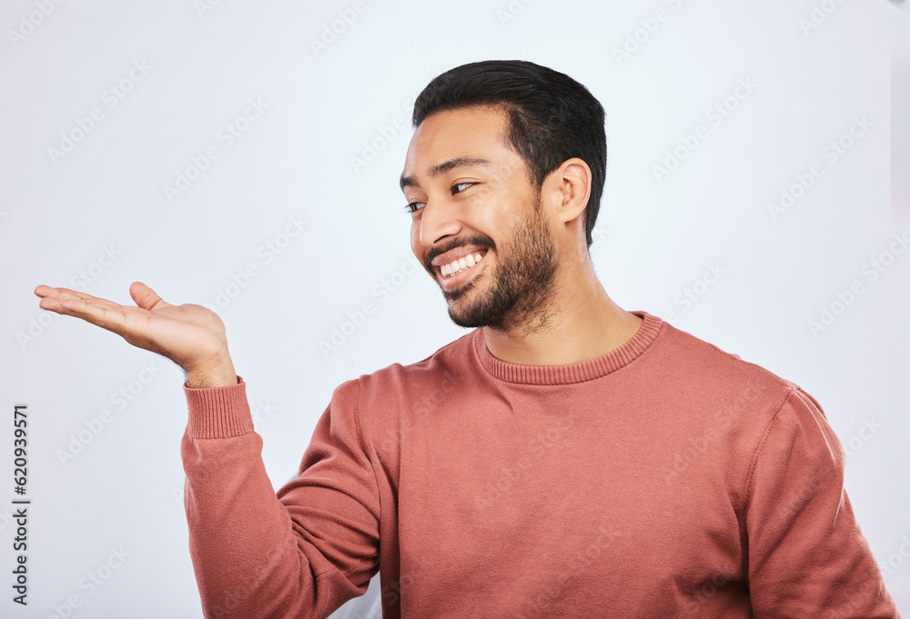 Hand holding, space and happy asian man in studio with mockup, promotion or news on grey background.