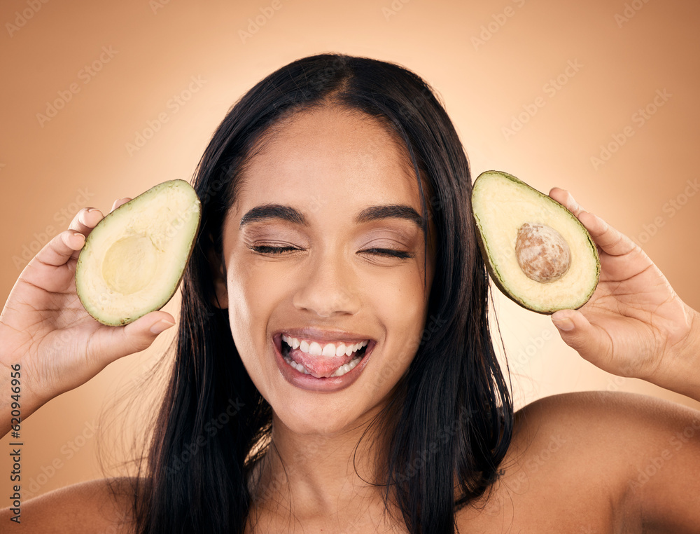 Face, tongue out and woman with avocado for skincare isolated on a brown background in studio. Fruit