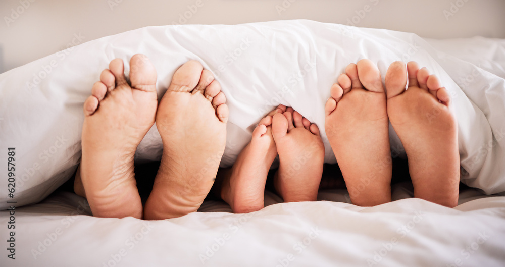 Sleeping, feet and family in bed together in the morning, lying in a row to relax in their home. Mom