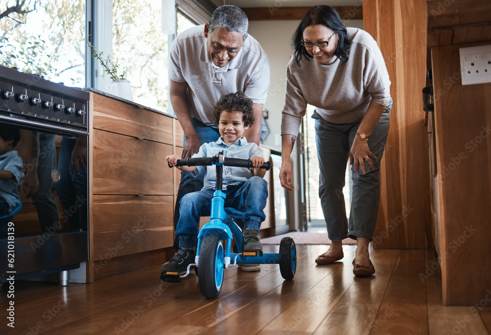 Grandparents, teaching child to ride and bike in kitchen, home or childhood memory of learning with 