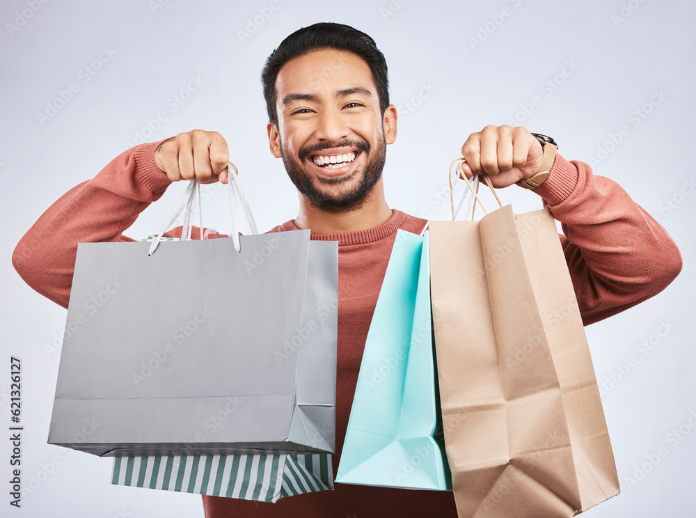 Shopping bag, studio portrait and happy man customer or client with retail product, gift or fashion 