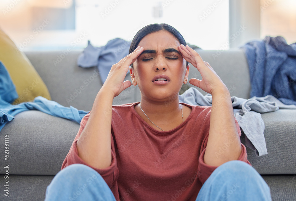 Headache, stress and woman with depression from laundry in a living room, exhausted and unhappy in h