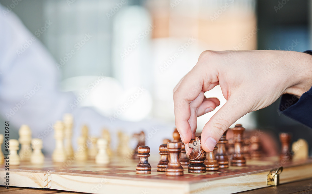 Chess, board game and hand of a man playing at a table while moving piece for strategy or checkmate.