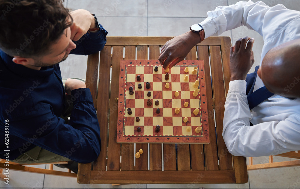 Chess, board game and men playing at a table from above while moving piece for strategy or challenge