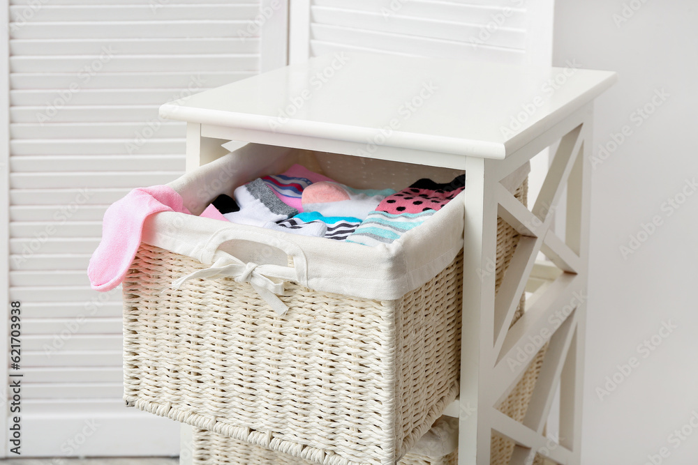 Drawer with basket of different socks near folding screen