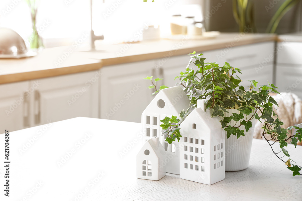 Table with stylish decor and houseplant in light kitchen, closeup