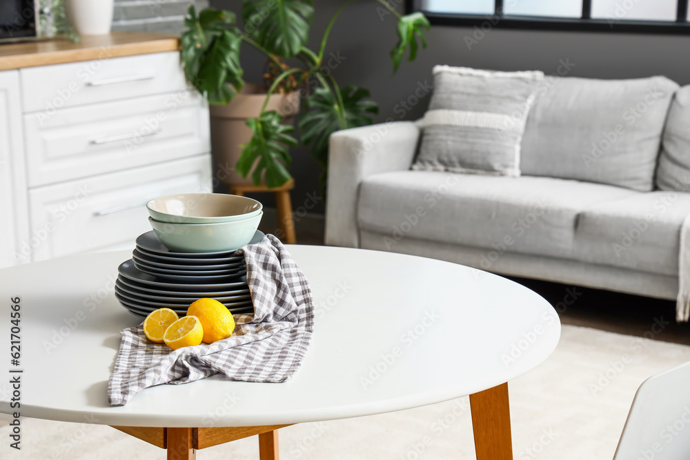 Table with lemons and plates in interior of light kitchen