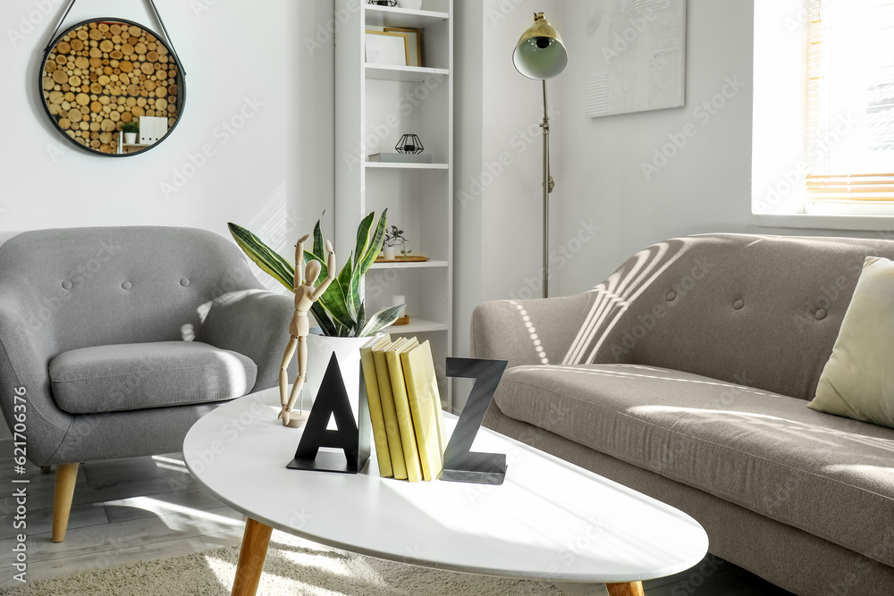 Bookend with wooden mannequin and houseplant on table in living room