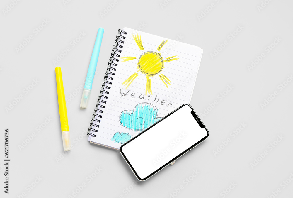 Notebook with word WEATHER, drawings and mobile phone on light background