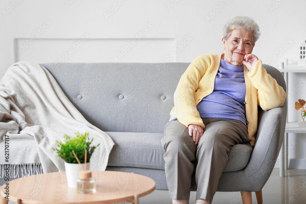 Senior woman sitting on sofa at home