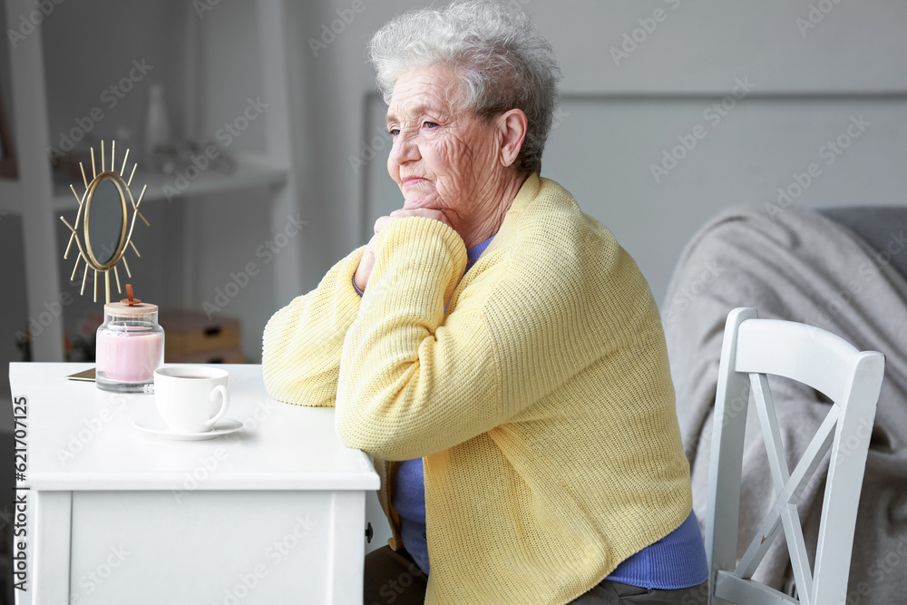 Thoughtful senior woman sitting at home