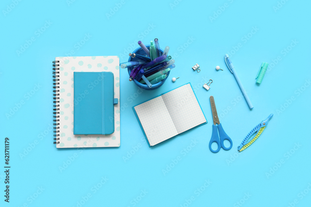 Composition with notebooks and different school stationery on blue background