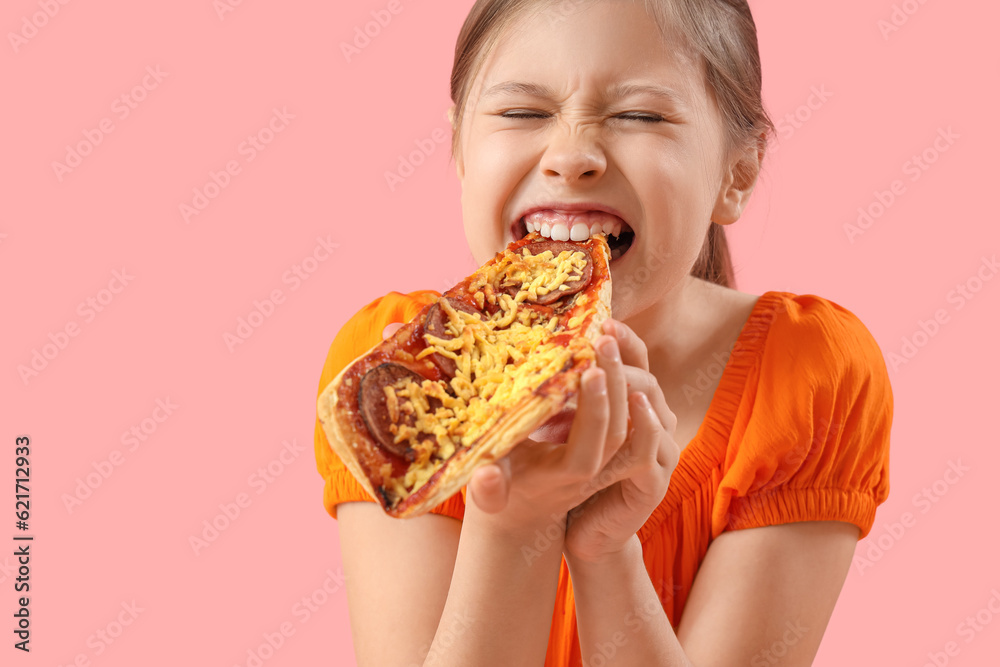 Angry little girl eating tasty pizza on pink background, closeup