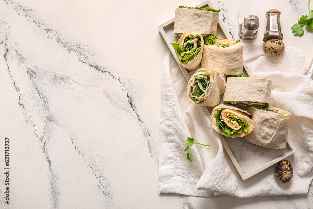 Plate of tasty lavash rolls with egg, onion and greens on white marble background