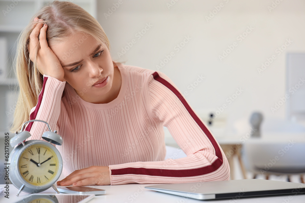 Stressed young businesswoman working under deadline in office